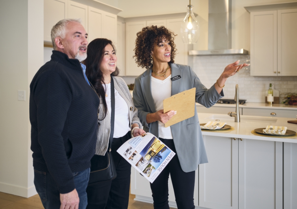 a saleswoman giving a tour to a couple